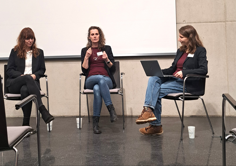 Die Moderatorin diskutiert mit den Podiumsteilnehmenden